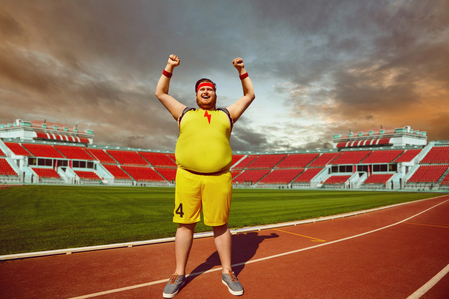 Fat man in sportswear shouts raised hands up standing in the stadium. Winner motivation concept.